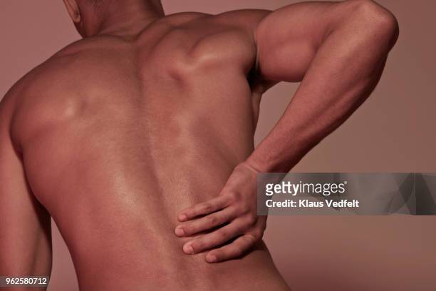 young man having back pains - bandscheibenvorfall stock-fotos und bilder