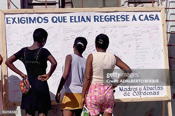 Women look at signatures in Cardenas, Cuba 06 December 1999 of those advocating the return of Elian Gonzales, who is in Miami. Mujeres de la ciudad...