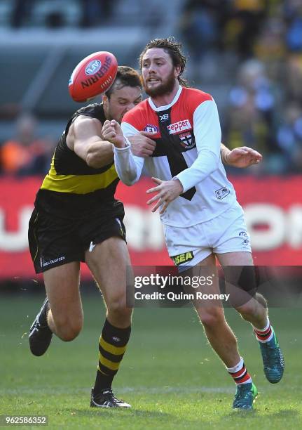 Jack Steven of the Saints handballs whilst being tackled by Toby Nankervis of the Tigers during the round 10 AFL match between the Richmond Tigers...