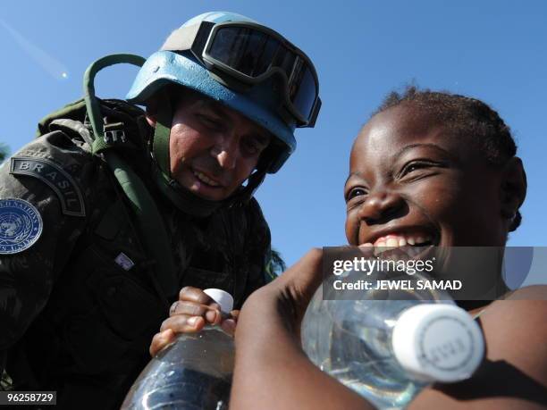 Haitians receive water from Brazilian UN peacekeepers at an aid distribution point by the Presidential palace in Port-au-Prince on January 22, 2010....