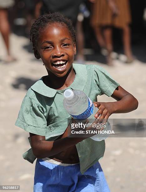 Girl runs with a bottle of water distributed by a Sri Lankan United Nations unit January 23, 2010 in Leogane, Haiti. The Sri Lankans handed out food...
