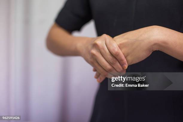 female clasping hands - emma baker stock pictures, royalty-free photos & images