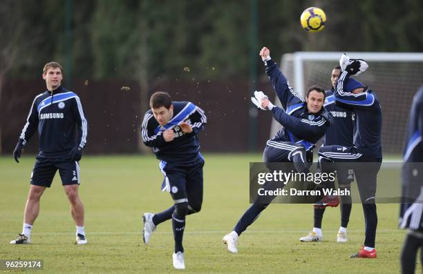 Ricardo Carvalho of Chelsea kicks the ball past Joe Cole and Ashley Cole during a training session at the Cobham Training Ground on January 29, 2010...