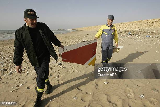 Lebanese civil defence workers carry parts of an Ethiopian airliner that crashed off Lebanon's coast as they walk on the shores of Khaldeh, south of...