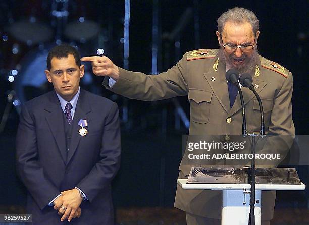 President of Cuba Fidel Castro speaks as Juan Miguel Gonzalez, father of child rafter Elian Gonzalez, listens after Castro presented him with the...