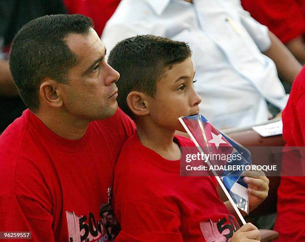 Cuban balsero boy Elian Gonzalez sits on the lap of his father Jose Miguel as they attend the celebration of the 50th anniversary of the Moncada...