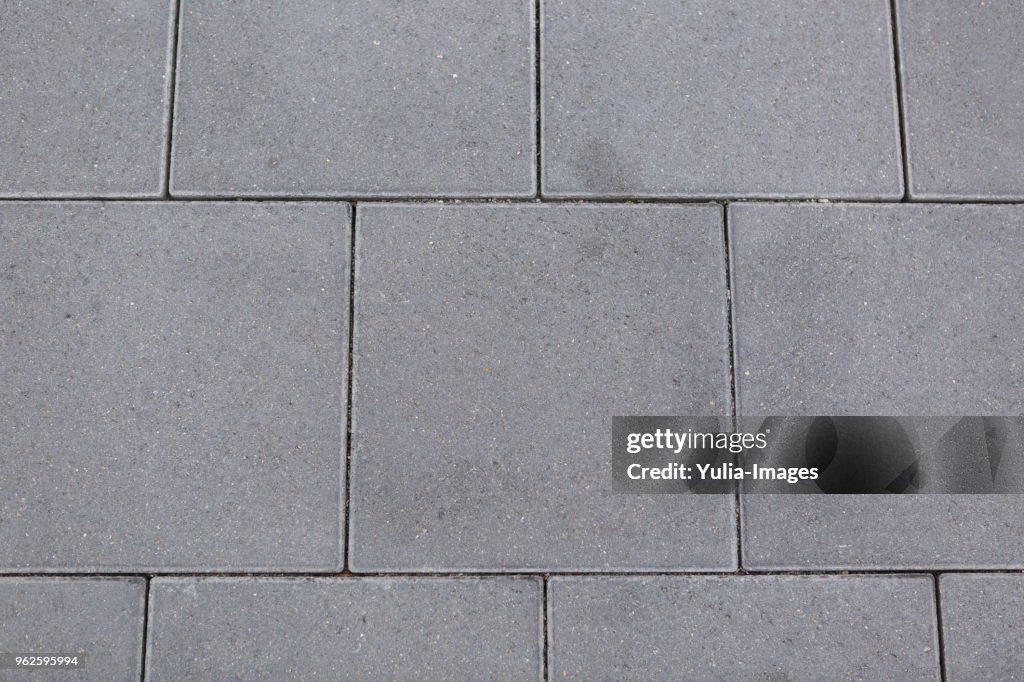 Textured grey square tiles for paving