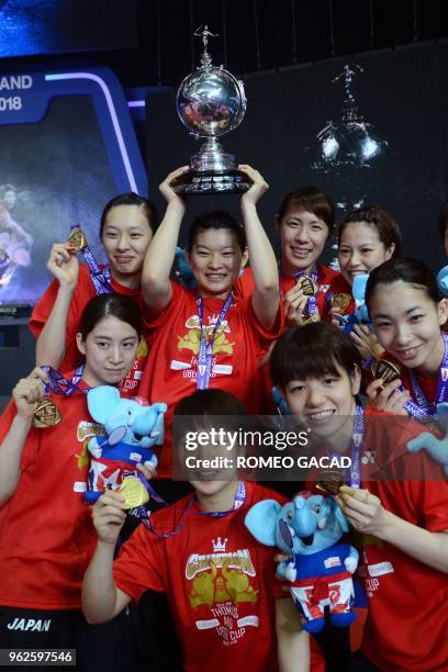 Japan's women team captain Ayaka Takahashi holds up their winning trophy as she poses with her teammates after defeating Thailand in their final...