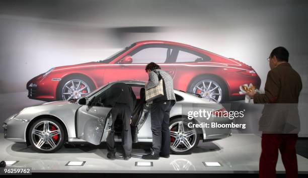 Visitors look at a Porsche 911 Carrera 4 S automobile at the company's annual shareholders' meeting, in Stuttgart, Germany, on Friday, Jan. 29, 2010....