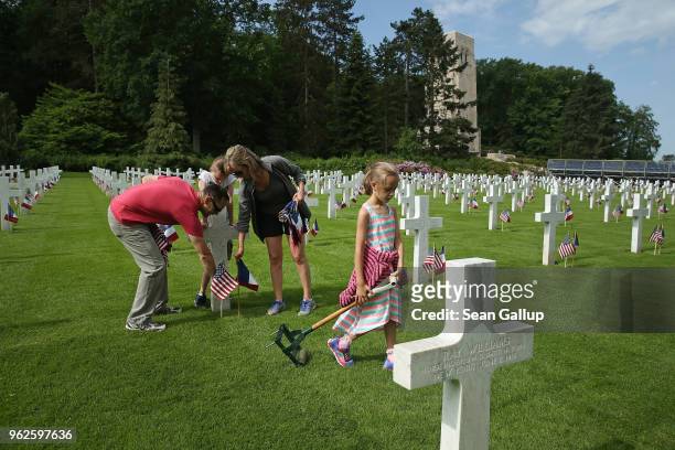 Marine Mark Weinrich, his wife Kathryn and their daughters Charlie and Emily help plant U.S. And French flags at the graves of U.S. Soldiers, most of...