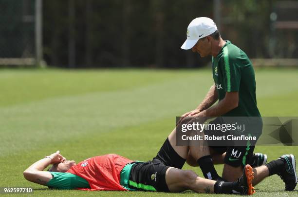 Mark Milligan of Australia is checked for a possible injury during the Australian Socceroos Training Session at the Gloria Football Club on May 26,...