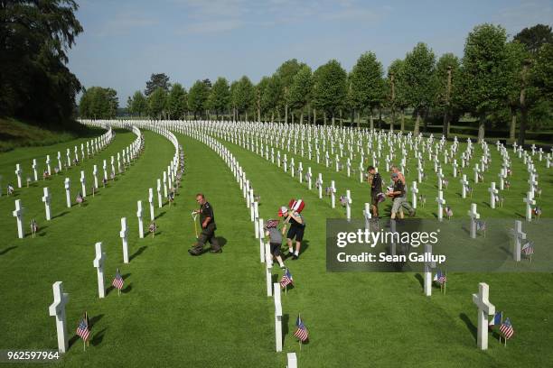 Workers and volunteers plant U.S. And French flags at the graves of U.S. Soldiers, most of them killed in the World War I Battle of Belleau Wood, at...