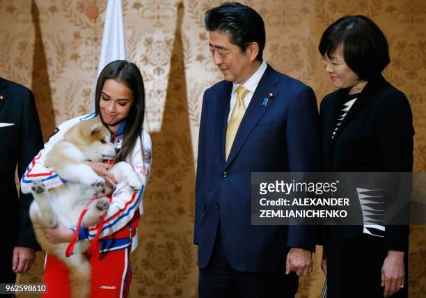 Russian figure skating gold medallist Alina Zagitova , Japanese Prime Minister Shinzo Abe and his wife Akie Abe poses with an Akita Inu puppy...