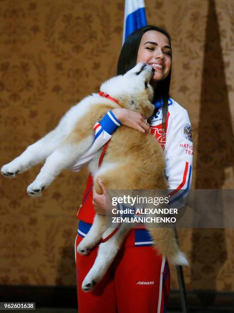 Russian figure skating gold medallist Alina Zagitova holds an Akita Inu puppy named Masaru in her arms presented by Japanese Prime Minister in Moscow...