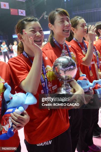 Japan's women team captain Ayaka Takahashi holds their winning trophy as she poses with her teammates after defeating Thailand in their final match...