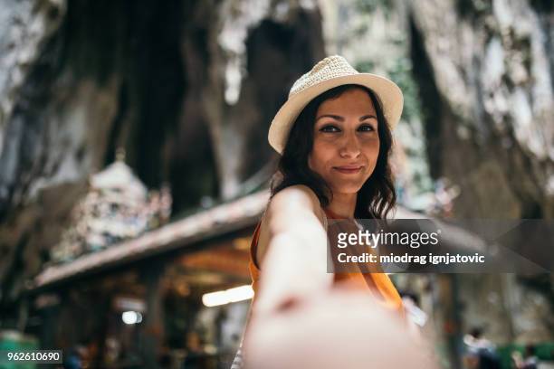 beautiful woman inside of the batu caves - batu caves stock pictures, royalty-free photos & images