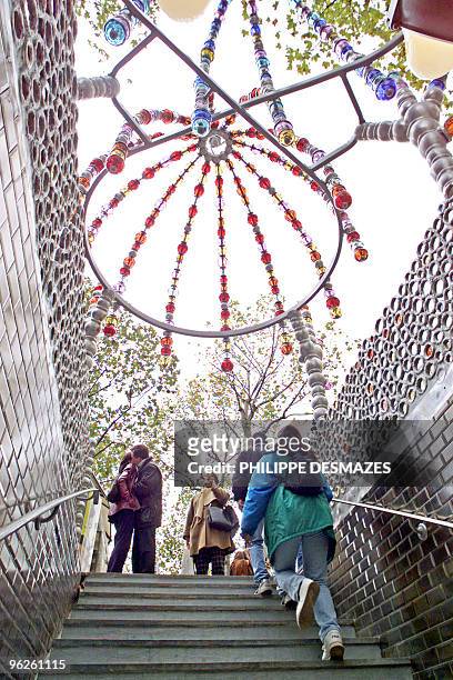Metro commuters step out of the Palais Royal underground station in central Paris 31 october 2000, which is adorned by glass and aluminium balls set...