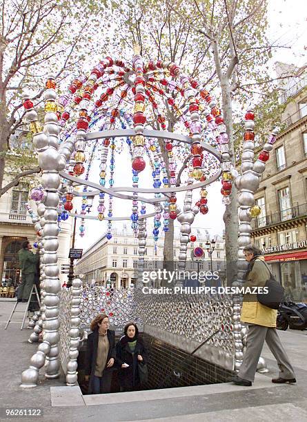 Commuter enters the Palais Royal underground station in central Paris 31 October 2000, which is adorned by glass and aluminium balls set up by French...