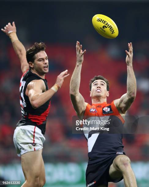 Jeremy Cameron of the Giants takes a mark under pressure from Matt Dea of the Bombers during the round 10 AFL match between the Greater Western...