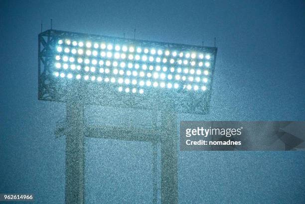 football stadium spotlight with heavy rain. - flutlicht stock-fotos und bilder