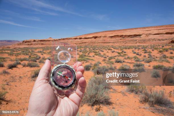 view of man holding compass in desert - coconino county stock pictures, royalty-free photos & images