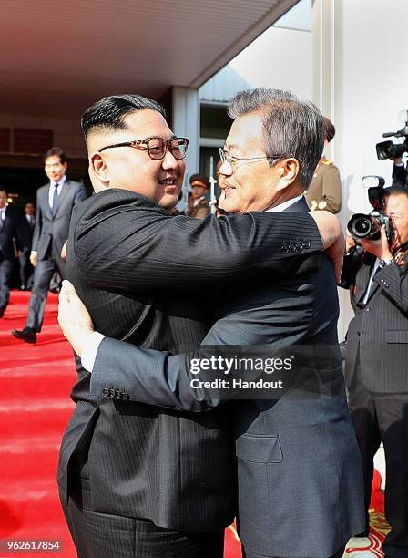 In this handout image provided by South Korean Presidential Blue House, South Korean President Moon Jae-in hugs with North Korean leader Kim Jong Un...