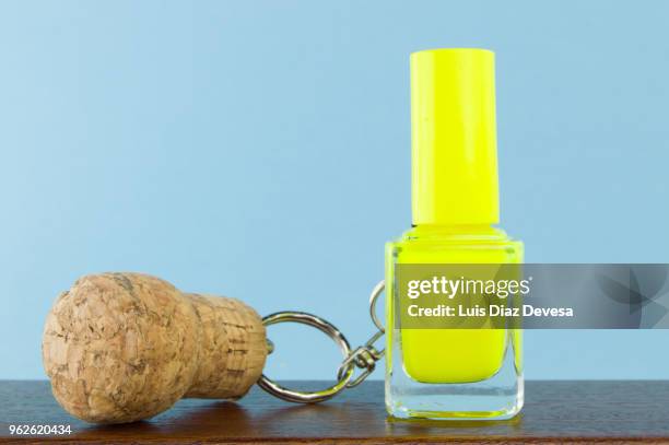 cava cork keyring holding  yellow nail polish - yellow nail polish stock-fotos und bilder