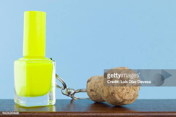 cava cork keyring holding  yellow nail polish - yellow nail polish stock-fotos und bilder