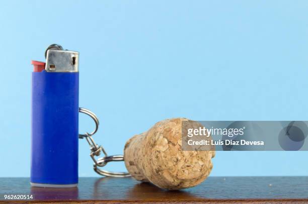 cava cork keyring holding blue cigarette lighter - bottle stopper 個照片及圖片檔