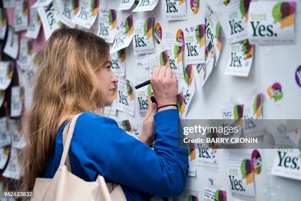 Woman writes a message on a mural to Savita Halappanavar, a 31-year-old Indian dentist, who died in 2012 due to the complications of a septic...