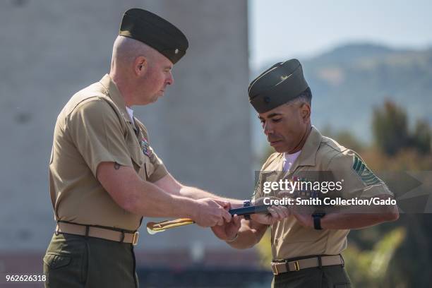 Photograph of Lieutenant Colonel David Handy handing a ceremonial sword to incoming Advanced Infantry Training Battalion Sergeant Major Jairo...