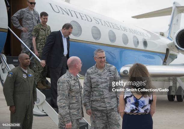 Photograph of air force officers including General John E Hyten and Colonel Troy L Endicott, and Tammy Endicott, greeting one another outside of a...