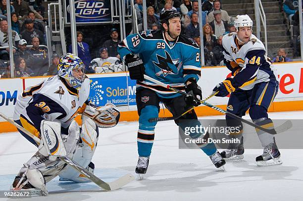 Ryane Clowe of the San Jose Sharks tries to maintain his position in front of the net between netminder Ryan Miller and Chris Butler of the Buffalo...