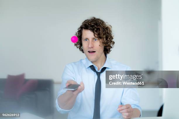 businessman playing ping pong with a ball and his mobile phone - tischtennis spielerin stock-fotos und bilder