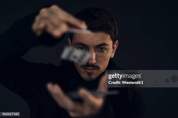 portrait of magician conjuring with playing cards - zauberer darstellender künstler stock-fotos und bilder