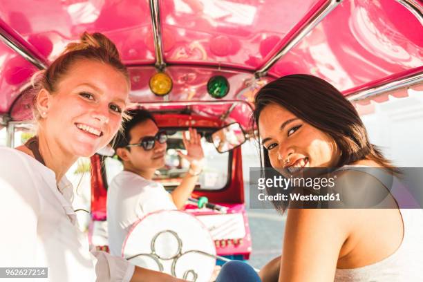 thailand, bangkok, portrait of smiling friends riding tuk tuk - motorriksha bildbanksfoton och bilder