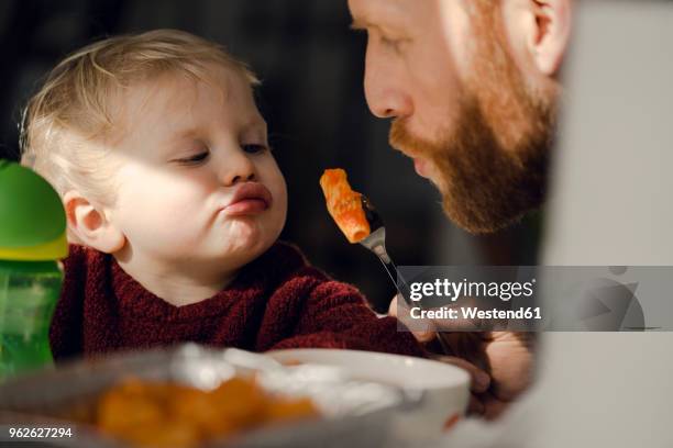 father feeding his little son with tasty pasta - baby feeding stockfoto's en -beelden