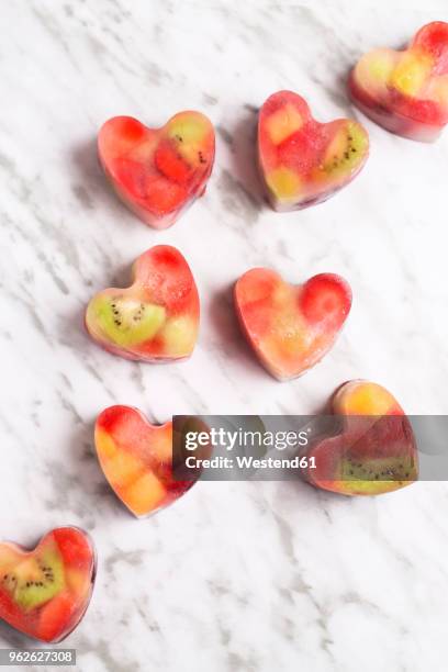 homemade heart-shaped ice cubes on marble - ice cube stock-fotos und bilder