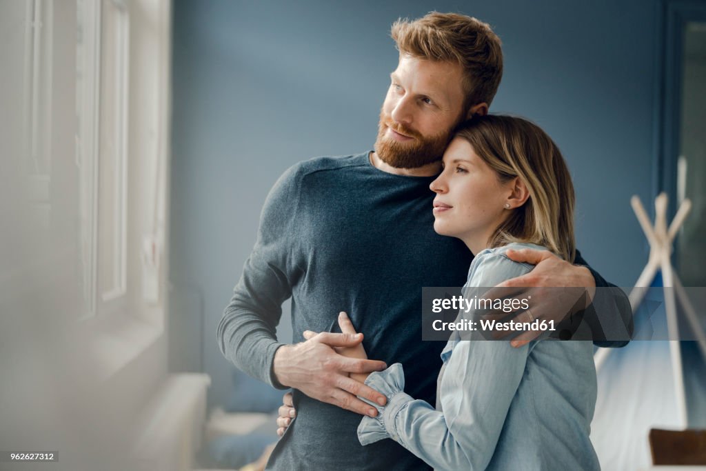 Happy couple embracing at home