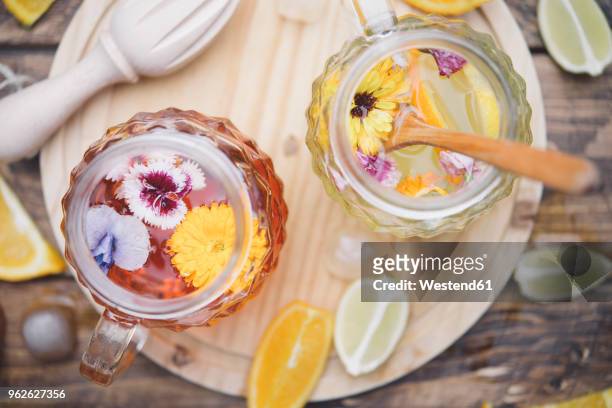 refreshing mineral water with edible flowers, viola wittrockiana, dianthus caryophyllus, calendula officinalis, lemon and orange - detox bildbanksfoton och bilder