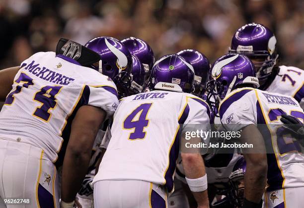 Bryant McKinnie, Brett Favre and Adrian Peterson of the Minnesota Vikings stand in the offensive huddle against the New Orleans Saints during the NFC...