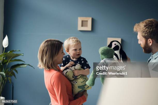 happy family playing with their son at home - stuffed toy stock-fotos und bilder