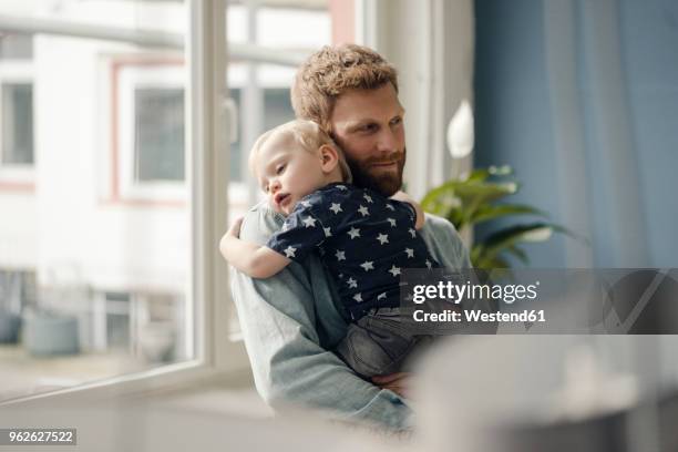 father spending time with his son at home - dad baby stock-fotos und bilder