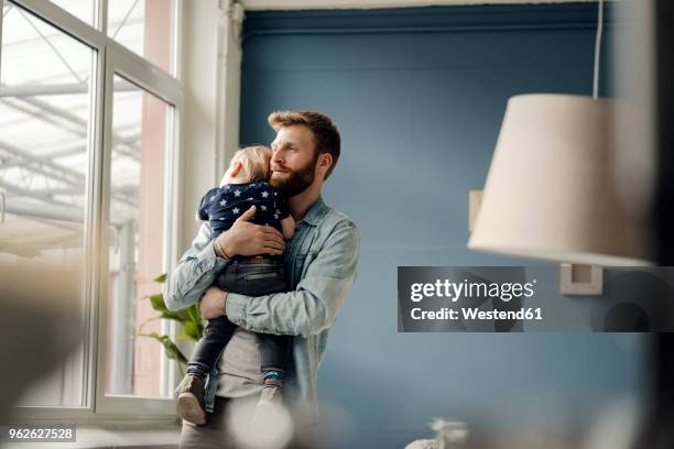 father spending time with his son at home - man baby carrier stock pictures, royalty-free photos & images