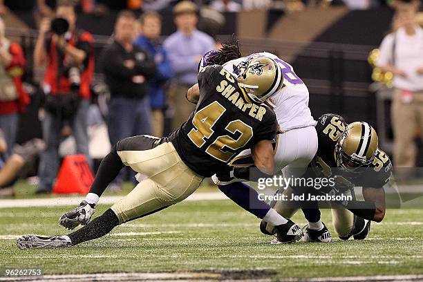 Darren Sharper and Jabari Greer of the New Orleans Saints tackle Sidney Rice of the Minnesota Vikings during the NFC Championship Game at the...