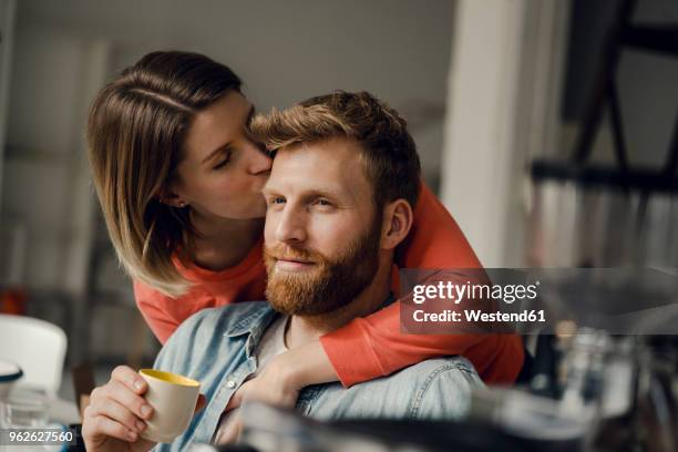 happy couple embracing at home - arm umlegen stock-fotos und bilder