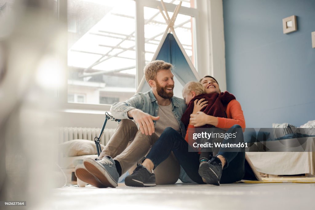 Happy family playing with their son at home