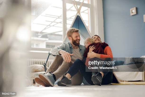 happy family playing with their son at home - couple laughing hugging stock pictures, royalty-free photos & images