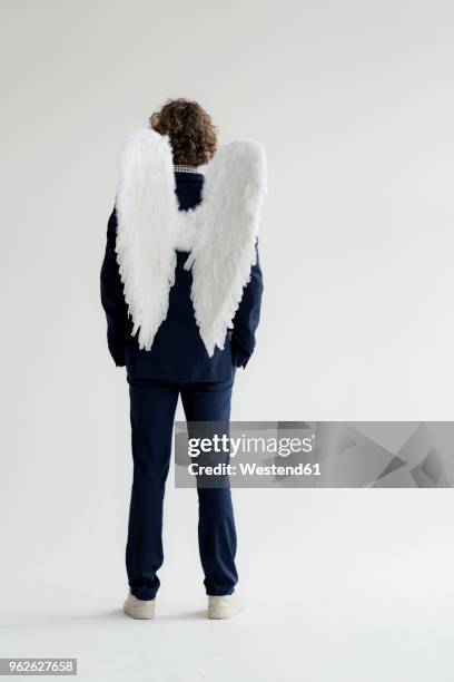 businessman wearing suit and angel's wings, rear view - man angel wings stock pictures, royalty-free photos & images