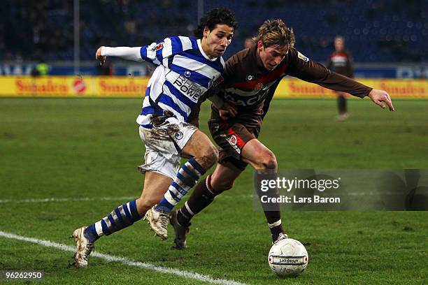 Olcay Sahan of Duisburg is challenged by Bastian Oczipka of St. Pauli during the Second Bundesliga match between MSV Duisburg and FC St. Pauli at MSV...